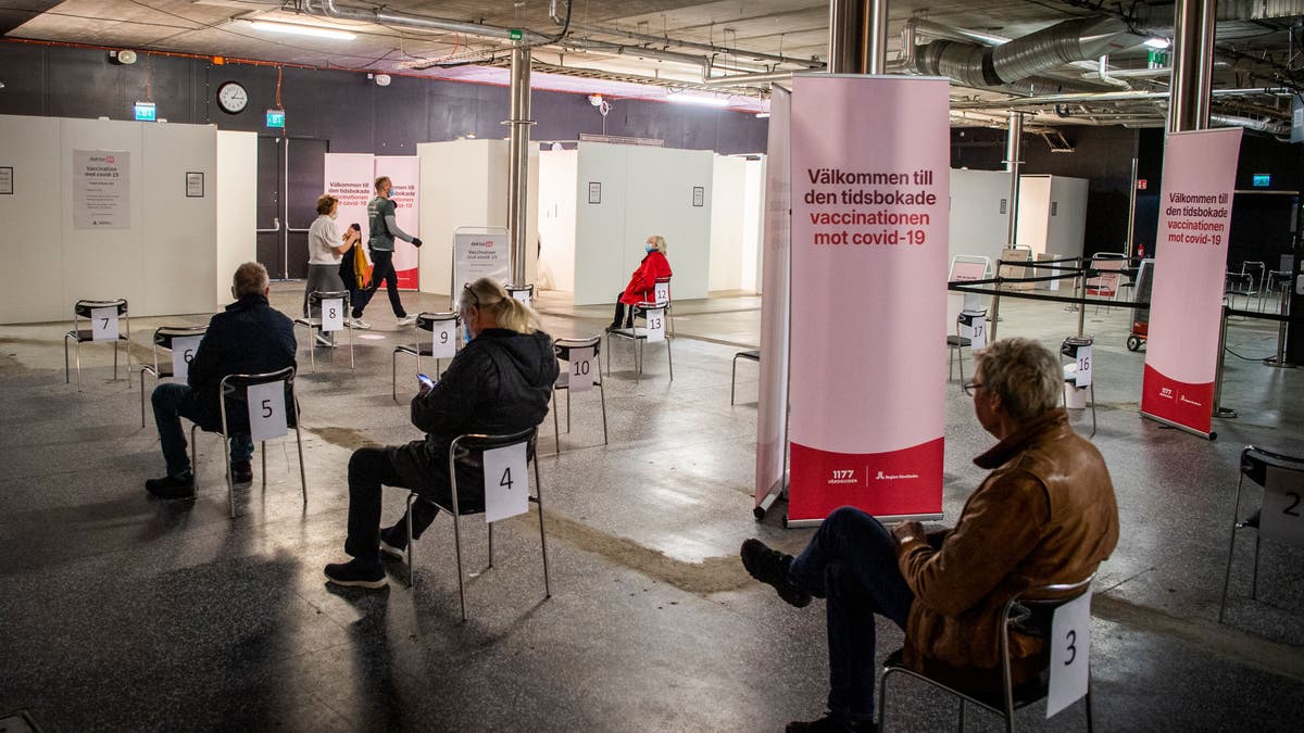 People wait to get their vaccines against Covid-19 in a night club turned mass vaccination center in Stockholm