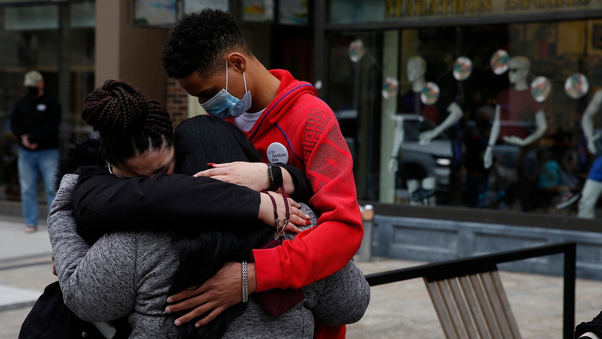 Joselyn Perez of Methuen, Massachusetts, left, who was at the Boston Marathon in 2013 and survived the bombing, embraces her mother, Sara Valverde Perez, who was hospitalized as a result of the bombing that day, in Boston on April 15, 2021. Joselyn's brother, Yoelin Perez, embraces them as church bells ring to mark the moment that the bombs went off eight years earlier.