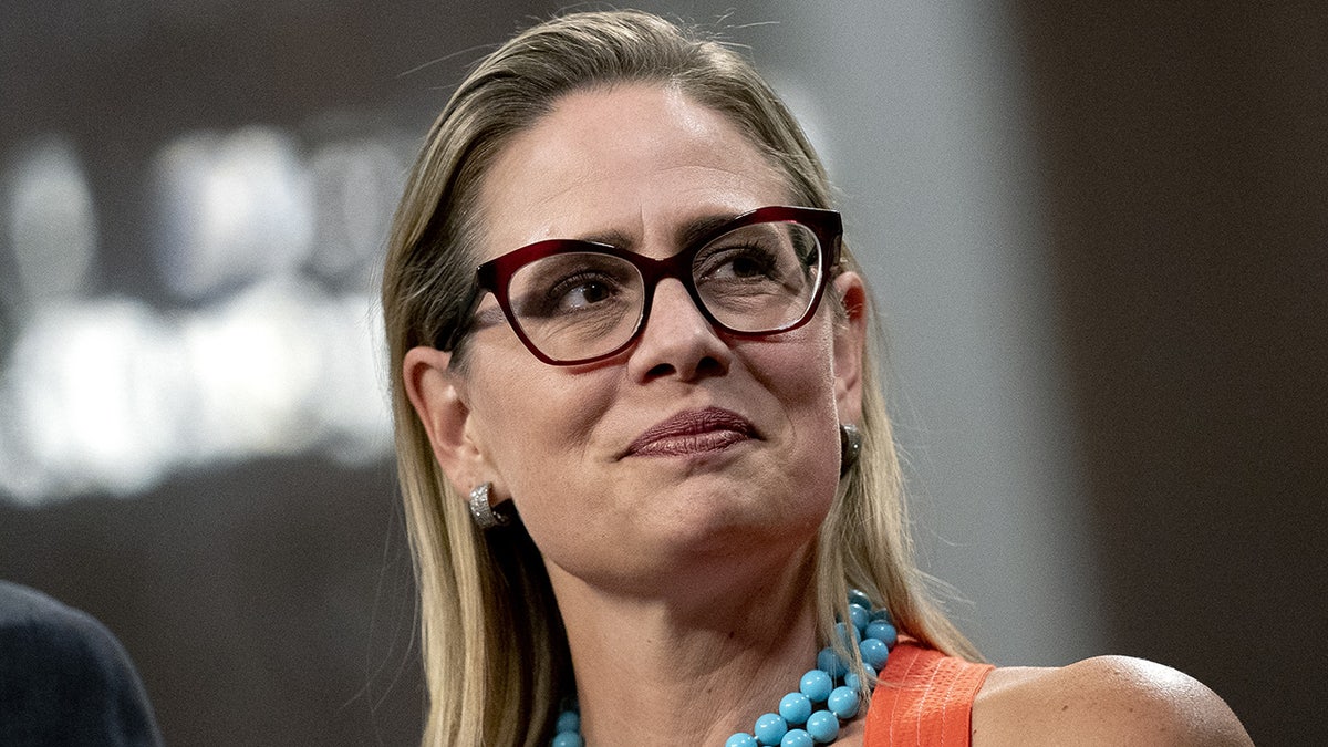 Democrat Arizona Sen. Kyrsten Sinema listening to people speaking