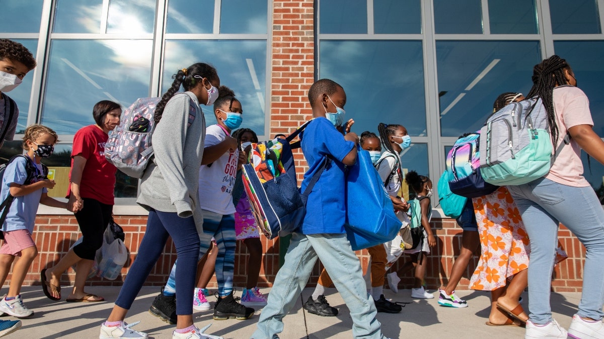 Students prepare to enter the building of Stratford Landing Elementary School in Alexandria, Virginia, on Monday, August 23, 2021, the first day back to school for many districts in northern Virginia. (Amanda Andrade-Rhoades/For The Washington Post via Getty Images)