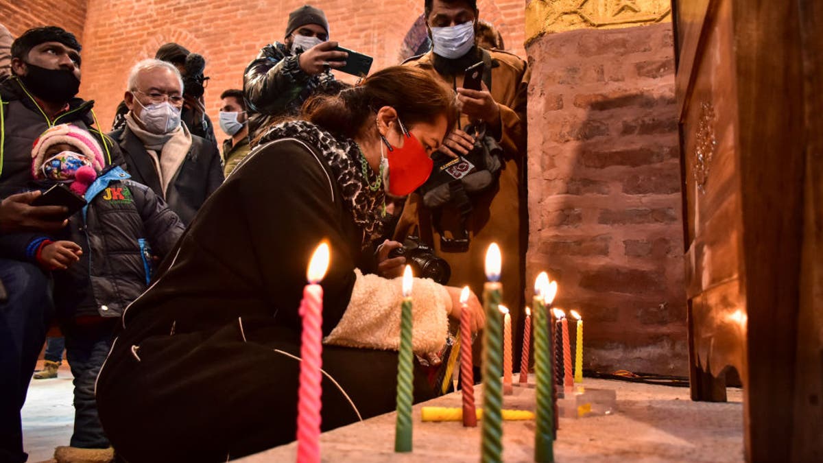 A Christian devotee lights candles inside St. Luke's Church on Christmas Day 2021 in Srinagar, India.