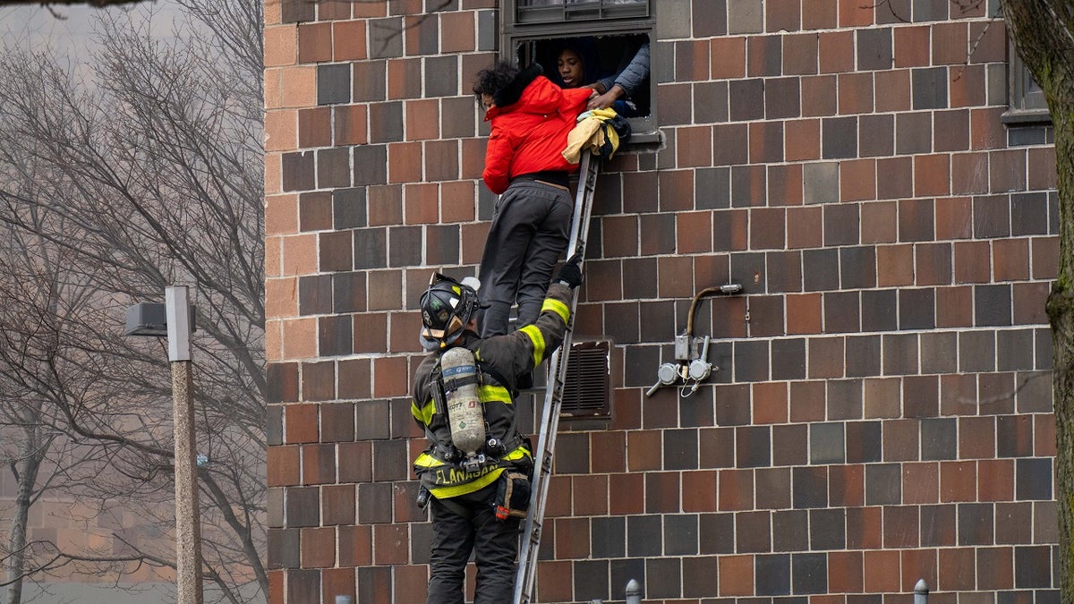 Firefighters hoisted a ladder to rescue people through their windows after a fire broke out inside a third-floor duplex apartment at 333 E. 181st St. in the Bronx Sunday. (Theodore Parisienne/New York Daily News/Tribune News Service via Getty Images)