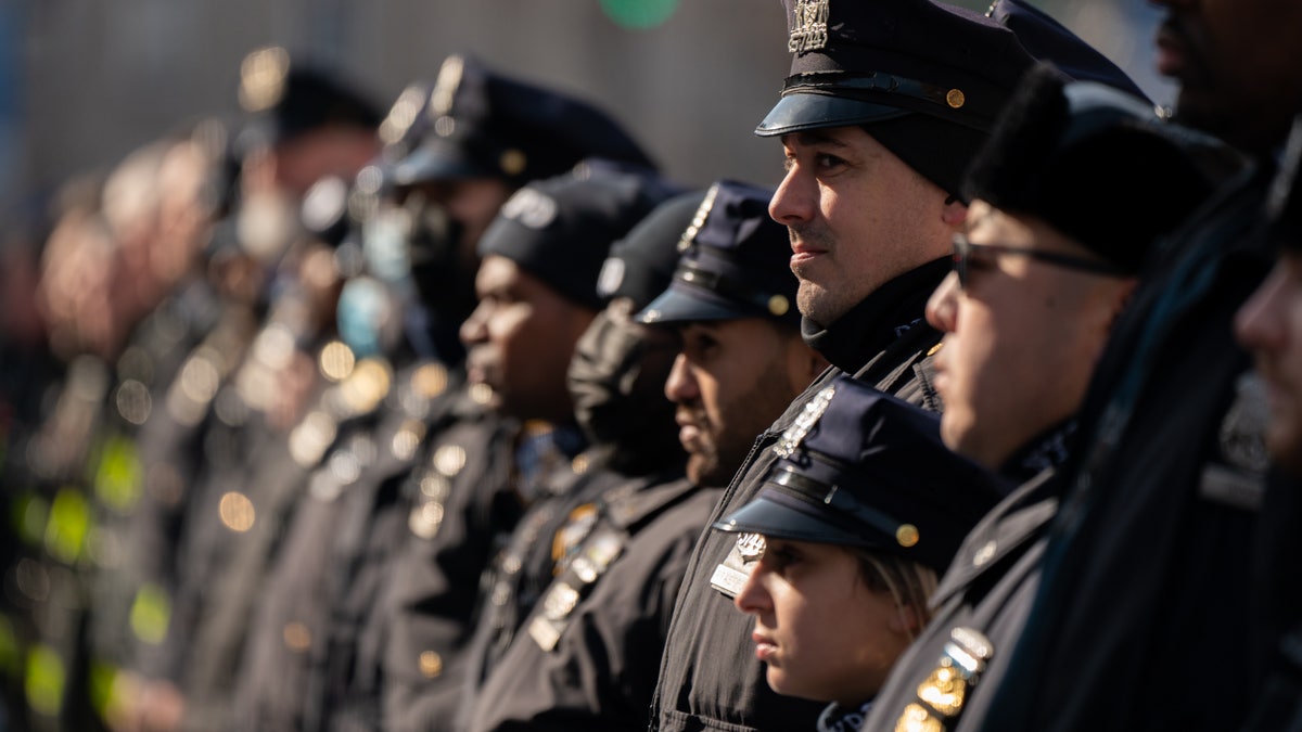 In this livestream frame grab from video provided by NYPD News, Mayor Eric Adams, foreground, with city law officials, speaks at a news conference inside a subway station after a woman was pushed to her death in front of a subway train at the Times Square station, Saturday, Jan. 15, 2022, in New York. (NYPD News via AP)