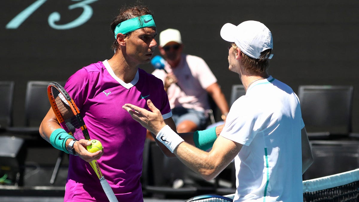 Spain's Rafael Nadal (L) talks to Canada's Denis Shapovalov during their men's singles quarterfinal match on day nine of the Australian Open tennis tournament in Melbourne on Jan. 25, 2022.