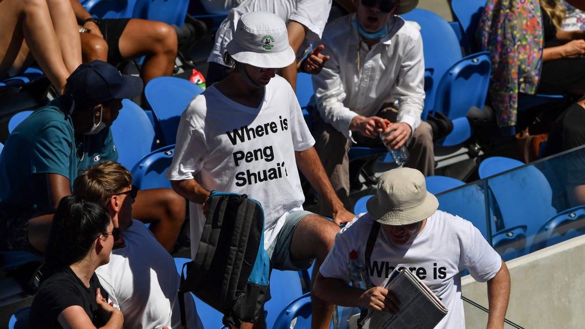 Two spectators wearing "Where is Peng Shuai?" T-shirts, referring to the former doubles world number one from China, are pictured in the stands on day nine of the Australian Open tennis tournament in Melbourne on Jan. 25, 2022.