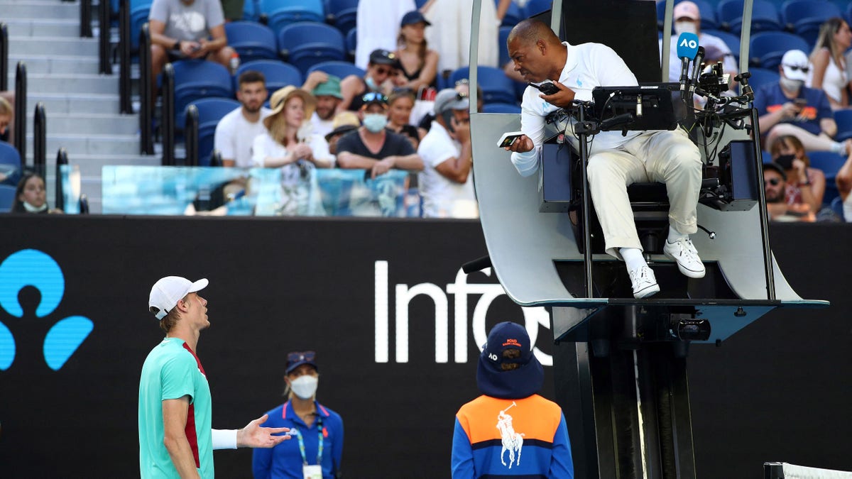 Canada's Denis Shapovalov speaks with the umpire while playing against Spain's Rafael Nadal during their men's singles quarterfinal match on day nine of the Australian Open tennis tournament in Melbourne on Jan. 25, 2022.