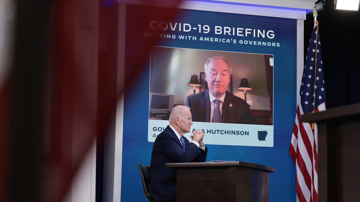 President Joe Biden listens as Gov. Asa Hutchinson