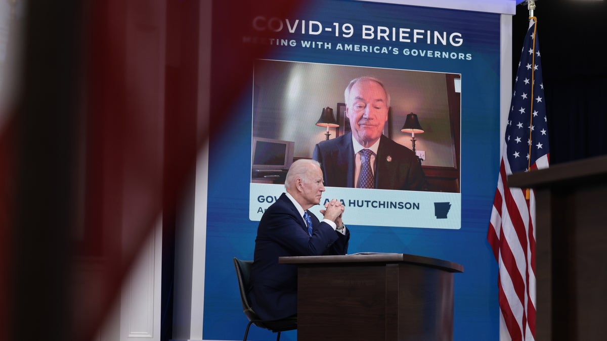 President Joe Biden listens as Gov. Asa Hutchinson