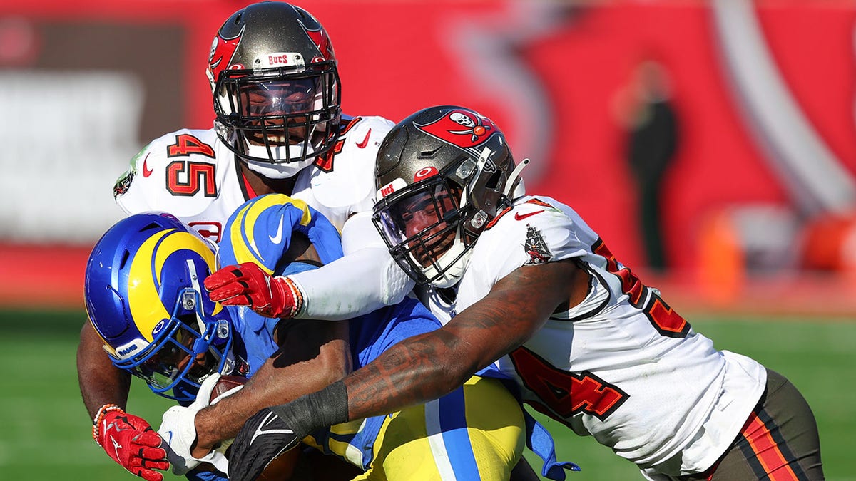 TAMPA, FLORIDA - JANUARY 23: Devin White #45 and Lavonte David #54 of the Tampa Bay Buccaneers defend as Cam Akers #23 of the Los Angeles Rams runs with the ball in the second quarter of the game in the NFC Divisional Playoff game at Raymond James Stadium on January 23, 2022 in Tampa, Florida.