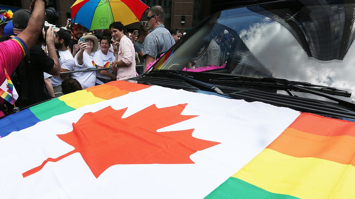 Justin Trudeau at Toronto Pride Parade, maple leaf pride flag in foreground