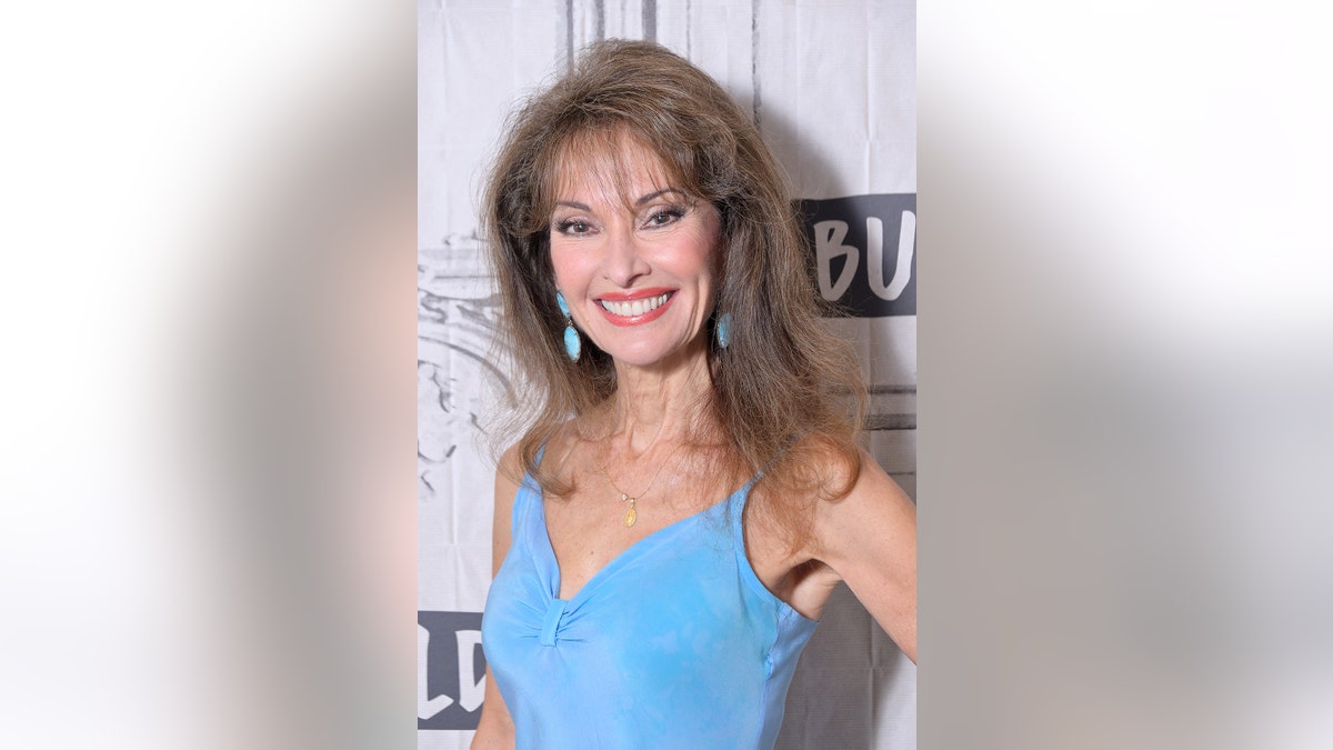 Susan Lucci wearing a blue top and blue dangling earrings