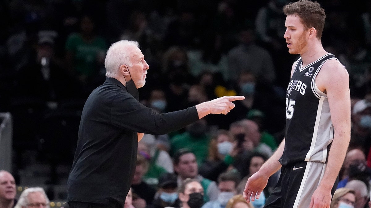 San Antonio Spurs head coach Gregg Popovich gestures towards San Antonio Spurs center Jakob Poeltl (25) during the first half of an NBA basketball game, Wednesday, Jan. 5, 2022, in Boston.