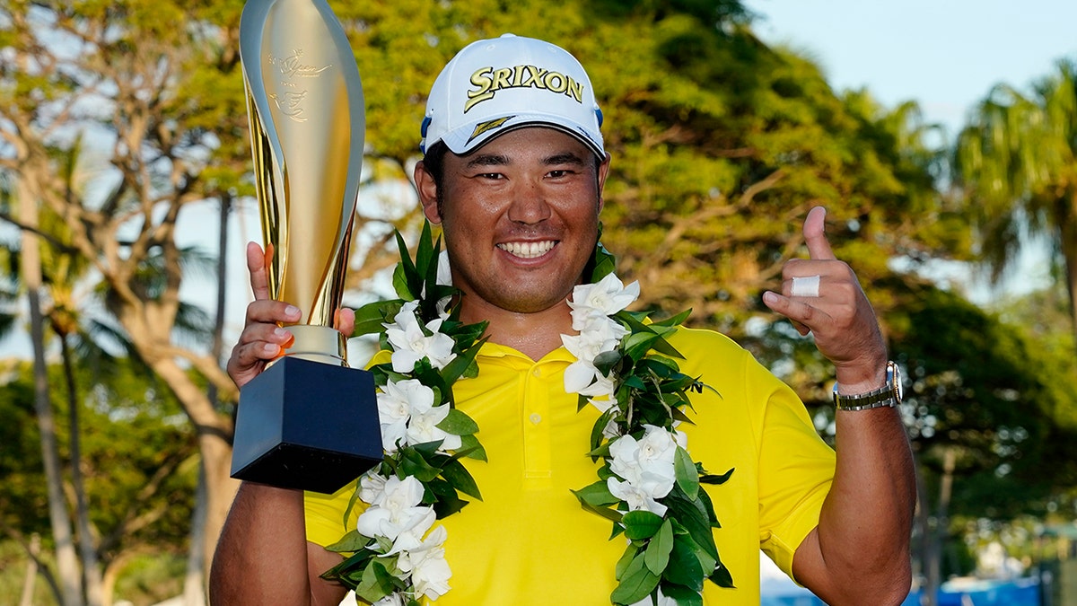 Hideki Matsuyama, of Japan, holds the champions trophy after the final round of the Sony Open golf tournament, Sunday, Jan. 16, 2022, at Waialae Country Club in Honolulu.