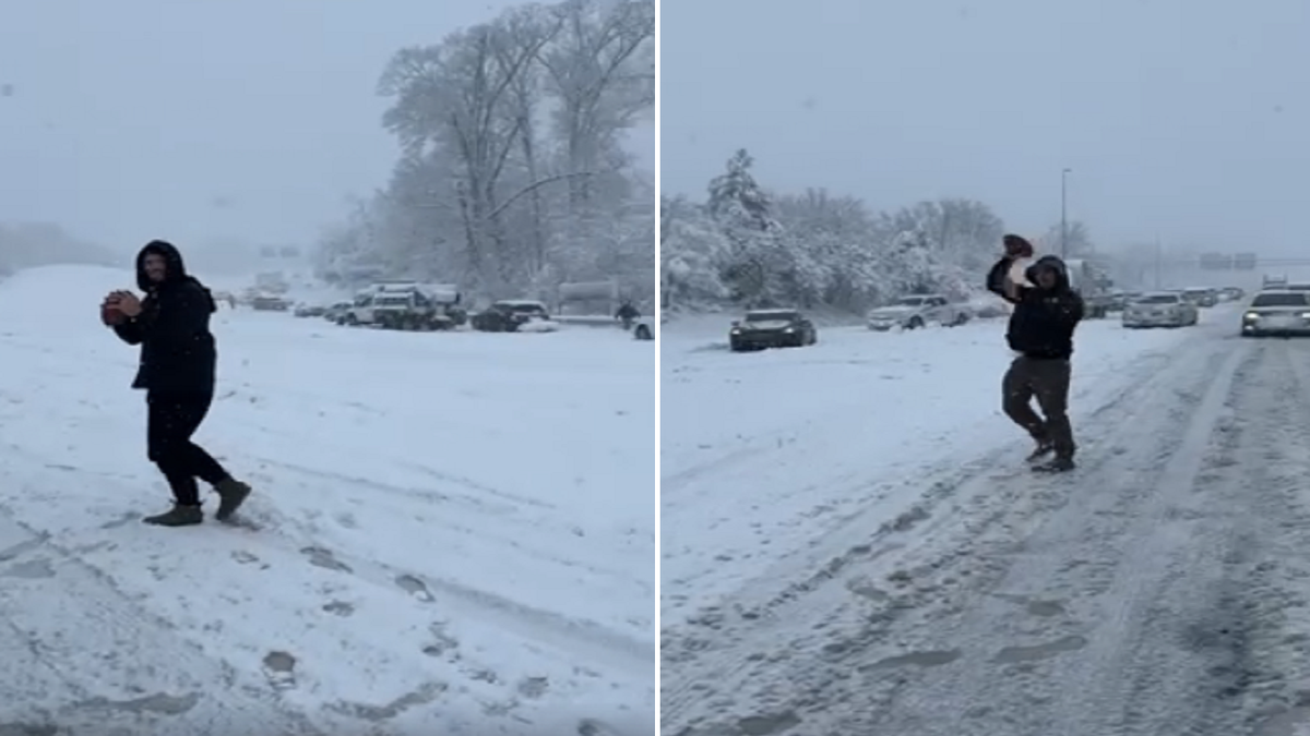 Two people toss a football while waiting for traffic to clear up along Interstate-95 in Virginia