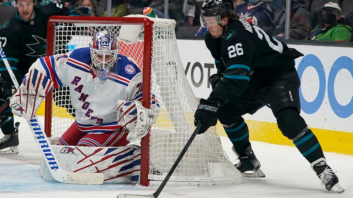 New York Rangers goaltender Igor Shesterkin, left, defends a shot attempt against San Jose Sharks center Jasper Weatherby (26) during the first period of an NHL hockey game in San Jose, Calif., Thursday, Jan. 13, 2022.