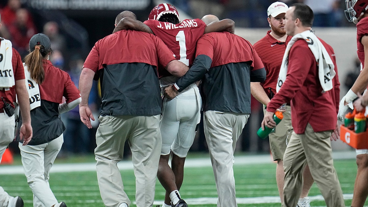 Alabama's Jameson Williams injures his knee after a catch during the first half of the College Football Playoff championship football game against Georgia Monday, Jan. 10, 2022, in Indianapolis.