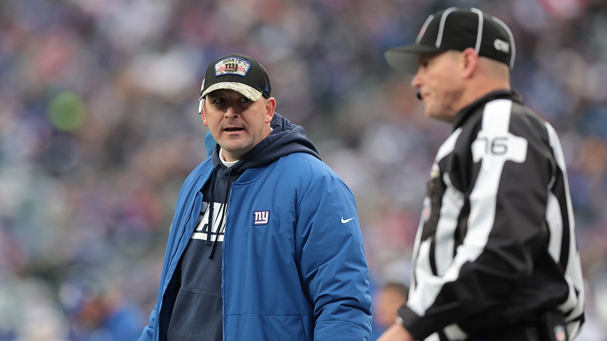 Nov 28, 2021; East Rutherford, New Jersey, USA; New York Giants head coach Joe Judge look back as side judge Alan Eck (76) during the second half against the Philadelphia Eagles at MetLife Stadium.