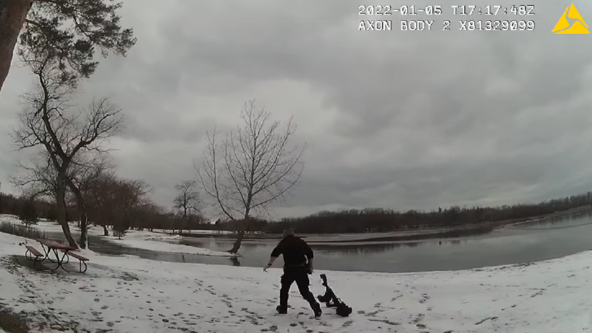 Lewiston Police Officer Jon Smith is seen dropping his equipment while racing out onto the lake to rescue the dog.