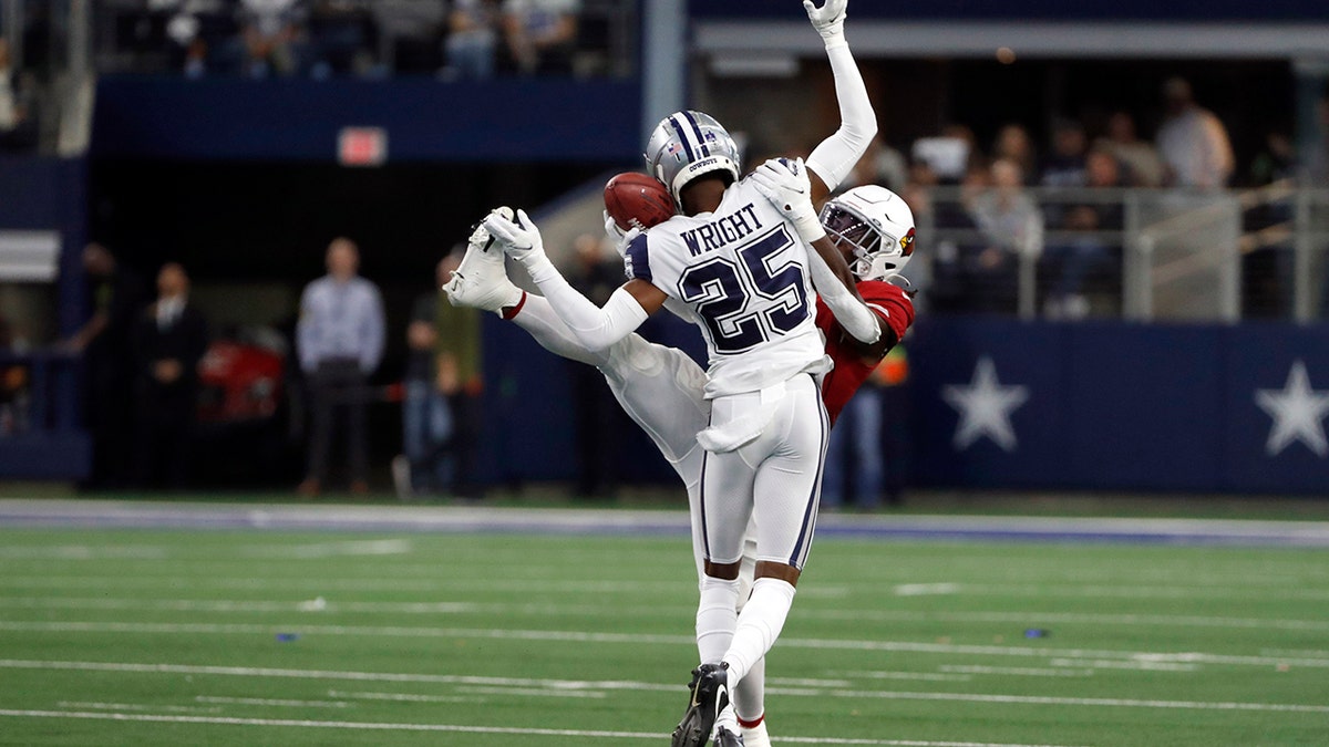 Dallas Cowboys cornerback Nahshon Wright (25) hits Arizona Cardinals running back Jonathan Ward (29) as he reaches to catch a pass during the first half of an NFL football game Sunday, Jan. 2, 2022, in Arlington, Texas. Wright was called for pass interference.