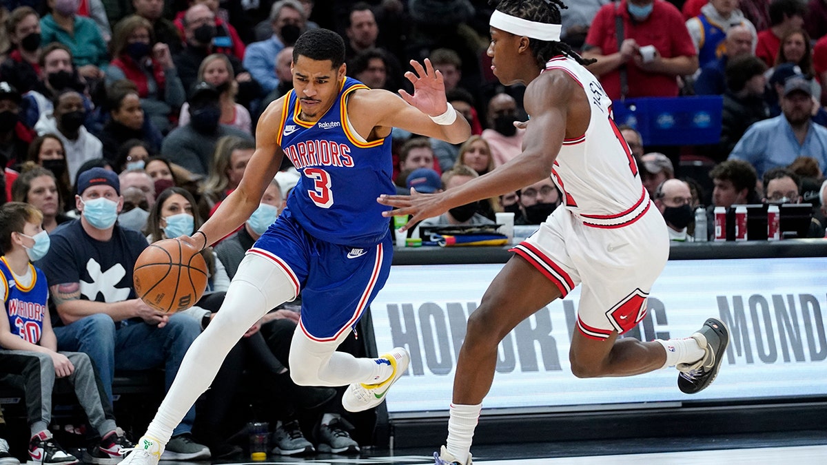 Golden State Warriors guard Jordan Poole, left, drives against Chicago Bulls guard Ayo Dosunmu during the first half of an NBA basketball game in Chicago, Friday, Jan. 14, 2022.
