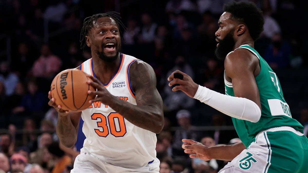 New York Knicks forward Julius Randle (30) looks to pass the ball around Boston Celtics guard Jaylen Brown during the first half of an NBA basketball game Thursday, Jan. 6, 2022, in New York.