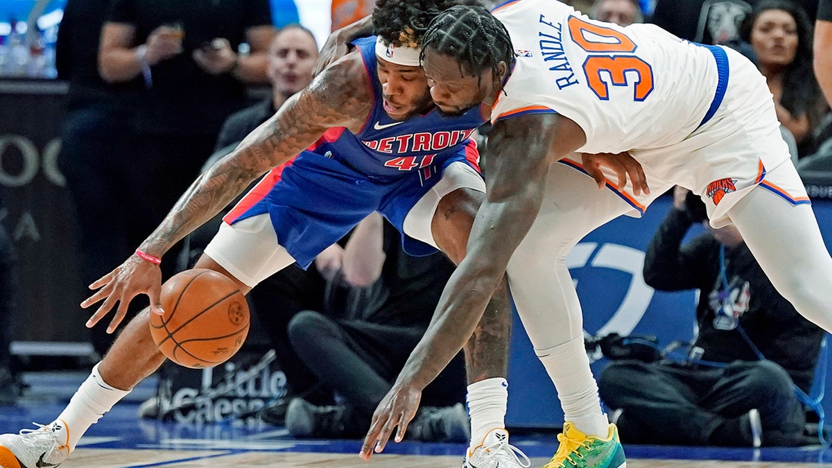 Detroit Pistons forward Saddiq Bey (41) and New York Knicks forward Julius Randle (30) reach for a loose ball during the second half of an NBA basketball game, Wednesday, Dec. 29, 2021, in Detroit.