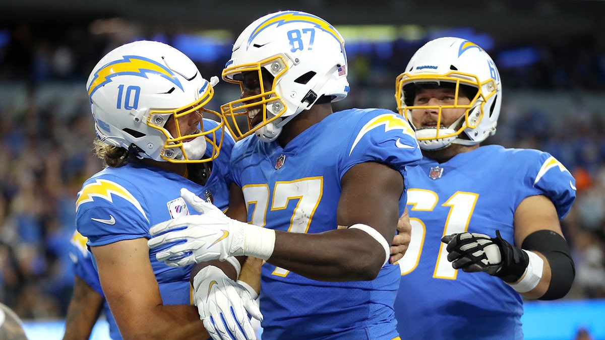 Jared Cook #87 of the Los Angeles Chargers celebrates his touchdown with teammates Justin Herbert #10 and Scott Quessenberry #61 during the second quarter against the Las Vegas Raiders at SoFi Stadium on October 04, 2021 in Inglewood, California.