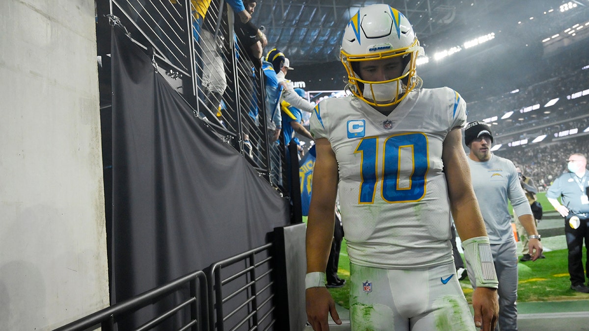 Los Angeles Chargers quarterback Justin Herbert (10) walks off the field after the Los Angeles Chargers lost to the Las Vegas Raiders in overtime of an NFL football game, Sunday, Jan. 9, 2022, in Las Vegas.