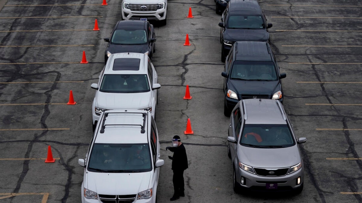 People wait to get tested at a mass COVID-19 testing event Friday, Jan. 14, 2022, in Overland Park, Kansas. 