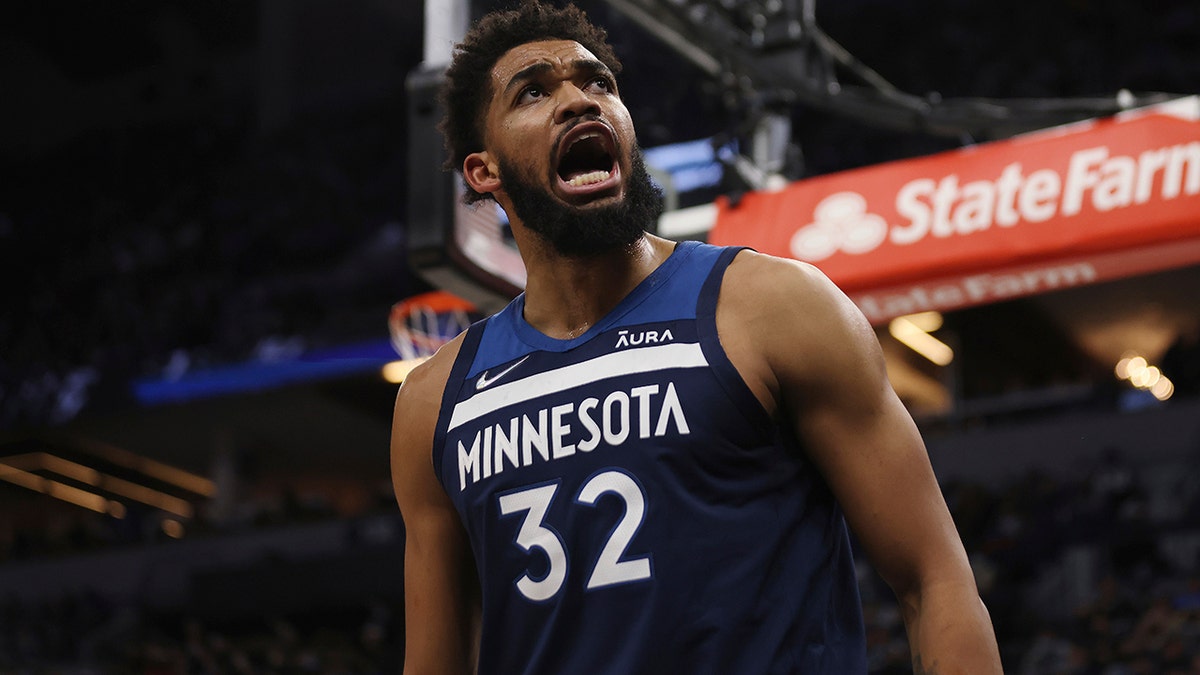 Minnesota Timberwolves center Karl-Anthony Towns (32) reacts after scoring a basket during the first half of an NBA basketball game against the Golden State Warriors, Sunday Jan. 16, 2022, in Minneapolis. 