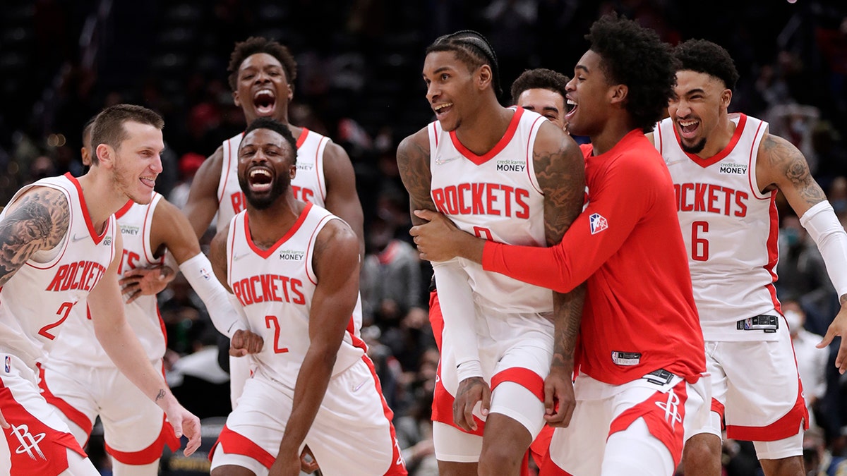 Houston Rockets Kevin Porter Jr., front second from right in front, celebrates with his teammates after making the game-winning 3-point shot in the team's NBA basketball game against the Washington Wizards, Wednesday, Jan. 5, 2022, in Washington.
