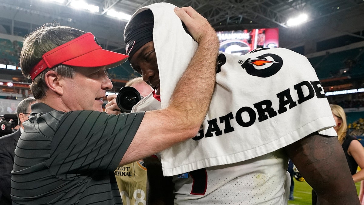 Georgia head coach Kirby Smart greets wide receiver Jermaine Burton after their win against Michigan in the Orange Bowl NCAA College Football Playoff semifinal game, Friday, Dec. 31, 2021, in Miami Gardens, Florida. Georgia won 34-11.
