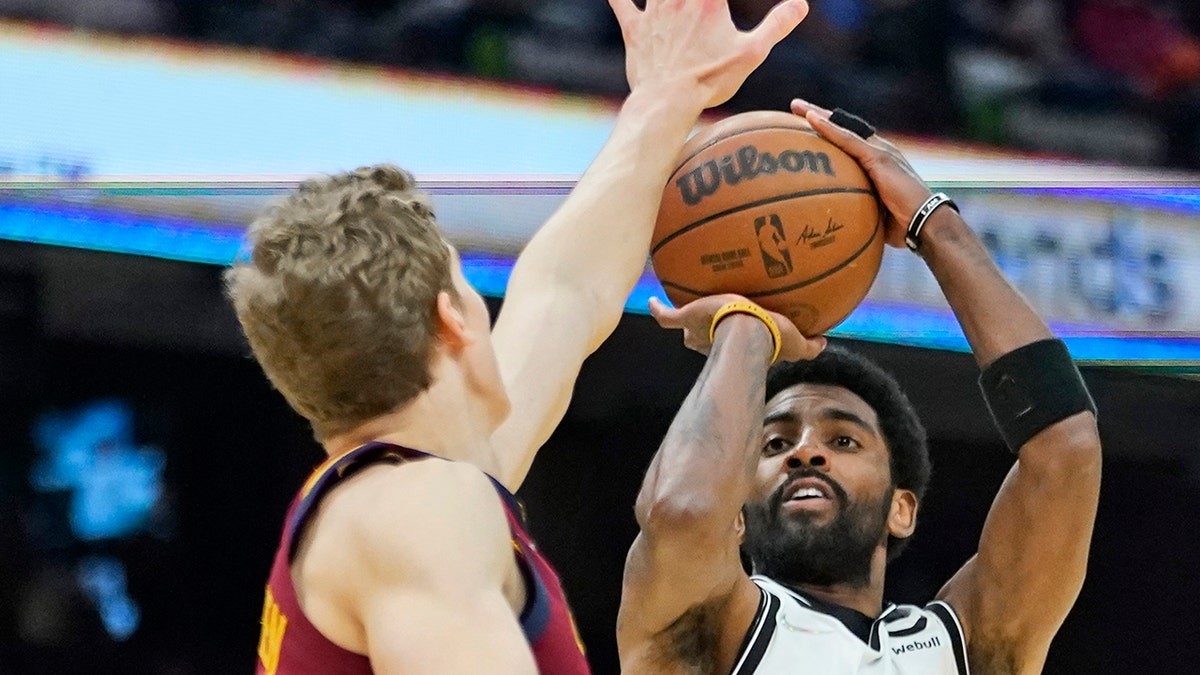 Brooklyn Nets' Kyrie Irving (11) shoots over Cleveland Cavaliers' Lauri Markkanen, left, in the second half of an NBA basketball game, Monday, Jan. 17, 2022, in Cleveland.