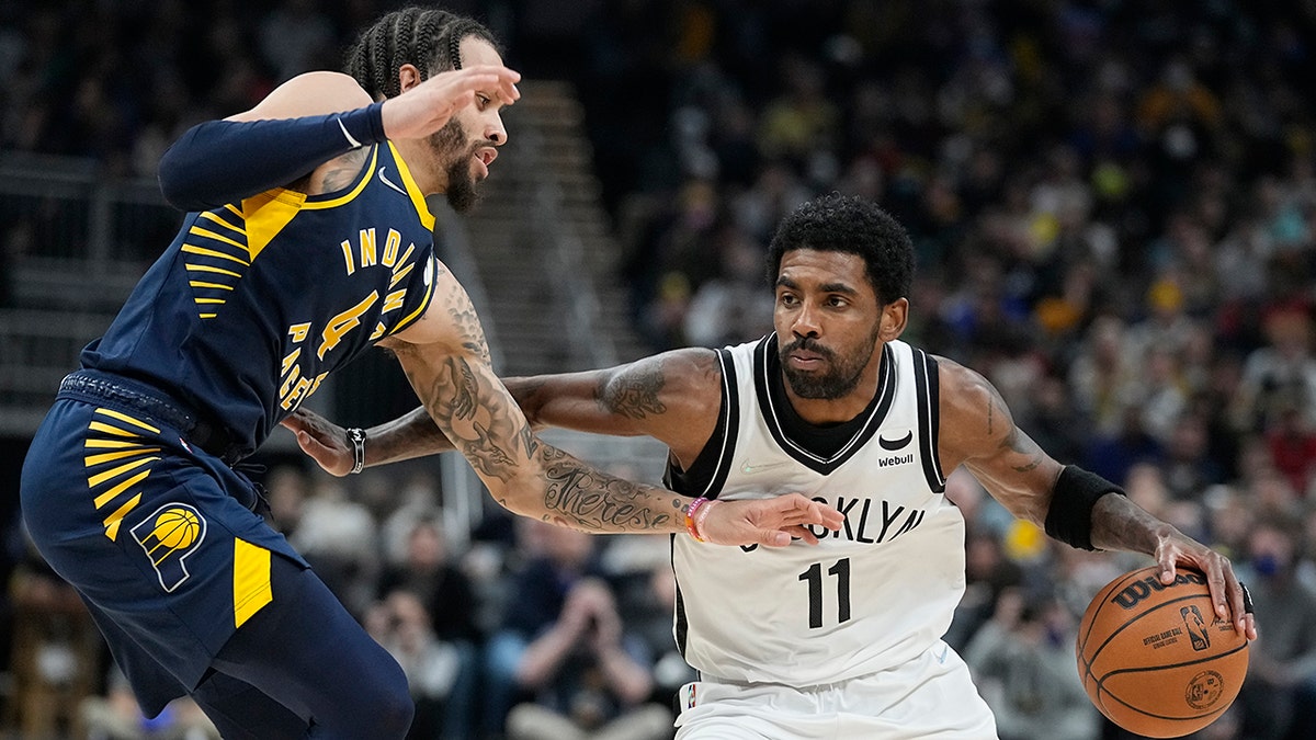 Brooklyn Nets' Kyrie Irving (11) is defended by Indiana Pacers' Duane Washington Jr. (4) during the first half of an NBA basketball game Wednesday, Jan. 5, 2022, in Indianapolis.