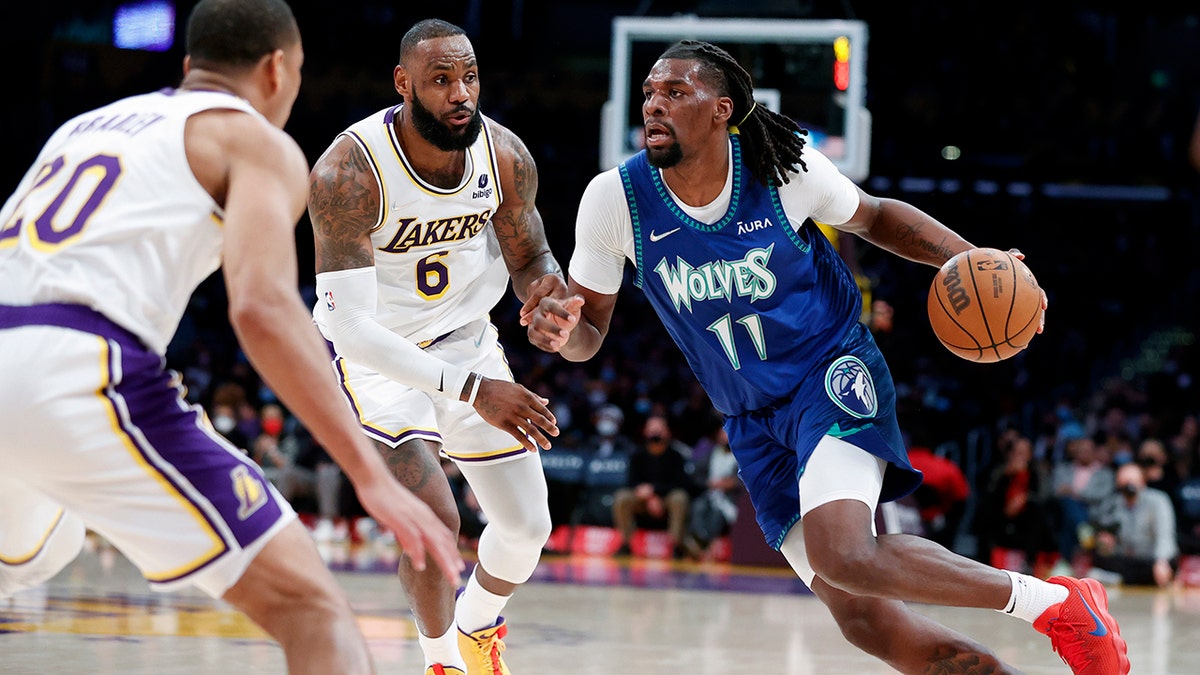 Minnesota Timberwolves center Naz Reid (11) drives against Los Angeles Lakers forward LeBron James (6) and guard Avery Bradley (20) during the second half of an NBA basketball game in Los Angeles, Sunday, Jan. 2, 2022. 