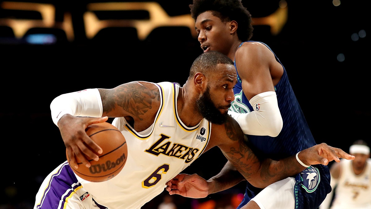 LeBron James of the Los Angeles Lakers drives against Jaden McDaniels of the Minnesota Timberwolves during the third quarter at Crypto.com Arena on Jan. 2, 2022, in Los Angeles, California.