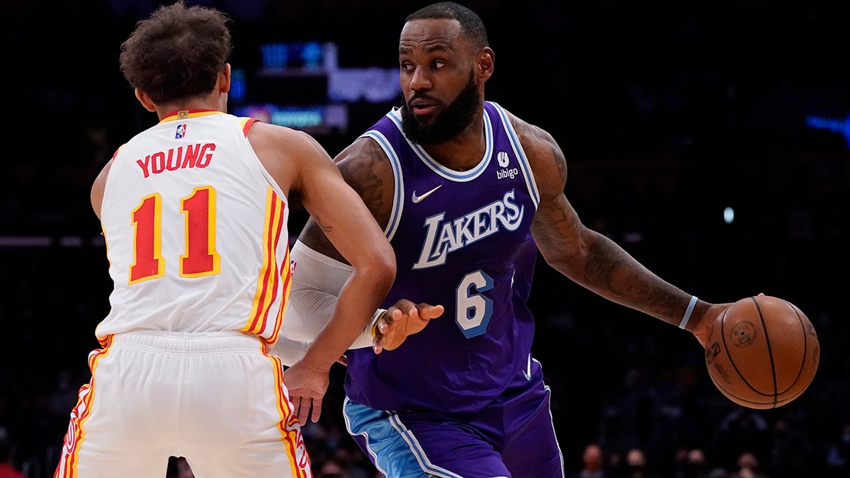 Atlanta Hawks guard Trae Young (11) defends against Los Angeles Lakers forward LeBron James (6) during the first half of an NBA basketball game in Los Angeles, Friday, Jan. 7, 2022.