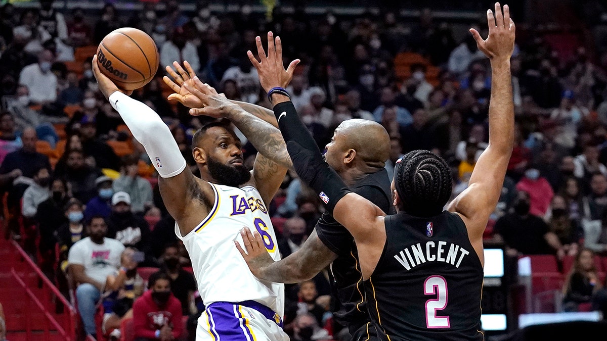 Los Angeles Lakers forward LeBron James (6) attempts to pass the ball as Miami Heat forward P.J. Tucker, center, and guard Gabe Vincent (2) defend during the first half of an NBA basketball game, Sunday, Jan. 23, 2022, in Miami.