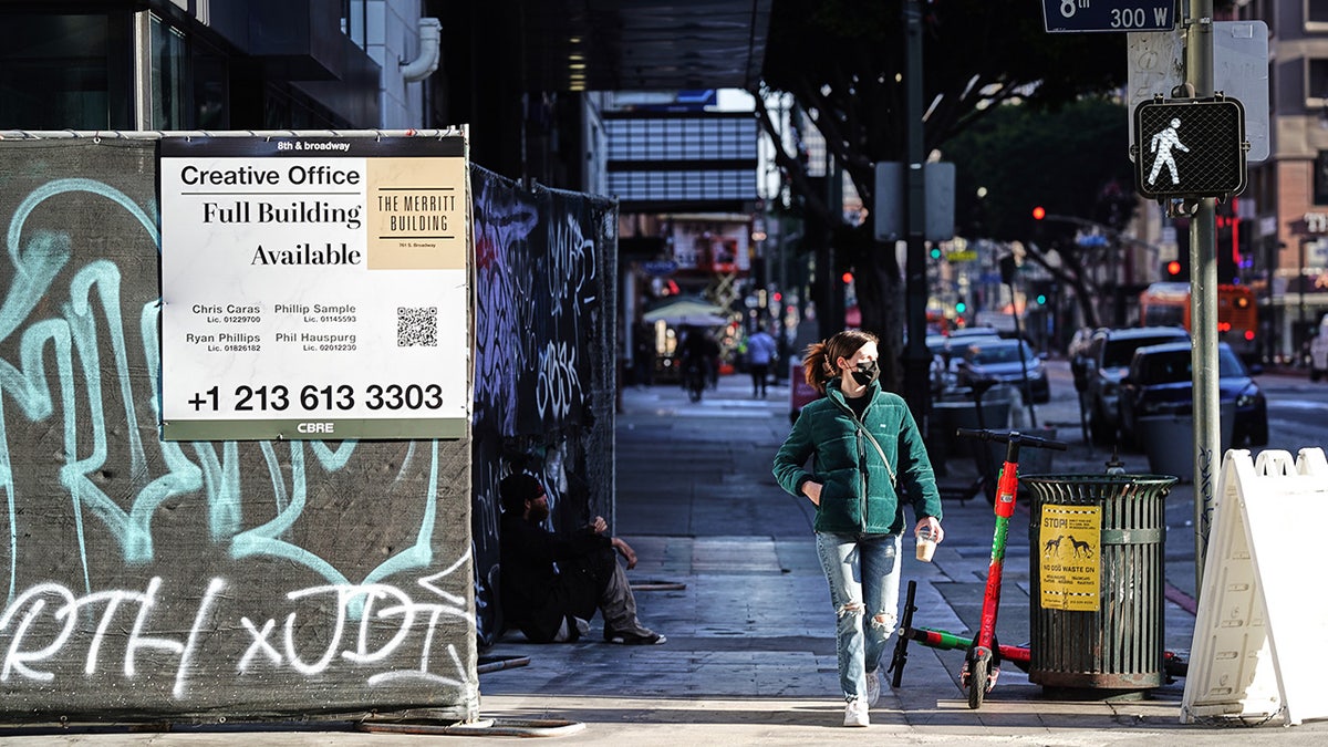 A pedestrian walks past a real estate sign at the Merritt Building in downtown Los Angeles, California, on Wednesday, Jan. 5, 2022. 