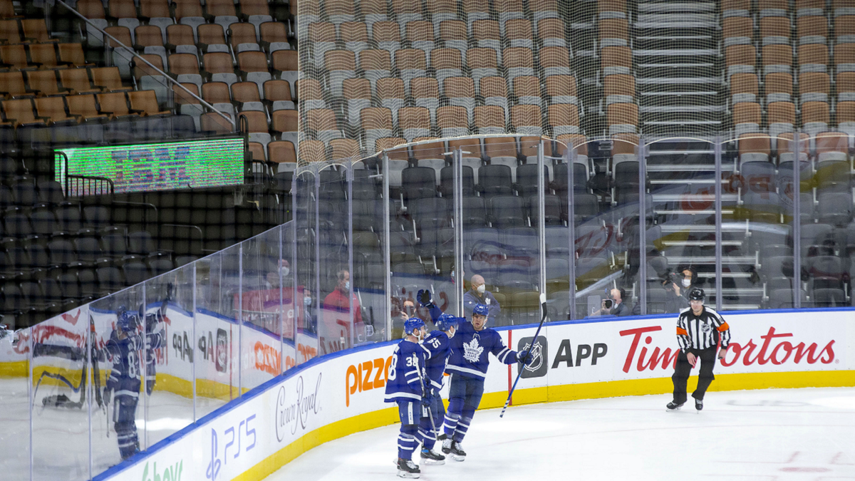 Toronto Maple Leafs' Ilya Mikheyev (65) celebrates with teammates after scoring his team's fifth goal against Ottawa Senators in front of empty seats during third period of an NHL hockey game in Toronto on Saturday.