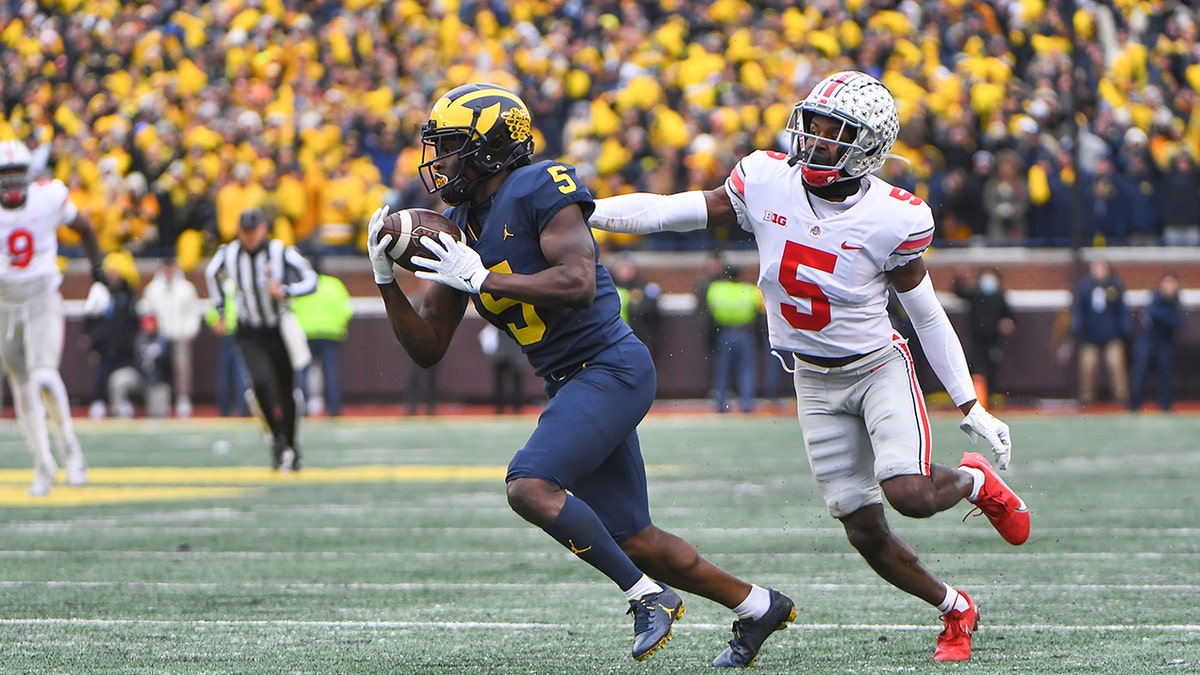 Michigan Wolverines wide receiver Mike Sainristil (5) makes a catch behind Ohio State Buckeyes cornerback Marcus Williamson (5) for a long gain inside the 10-yard line during a game Nov. 27, 2021, at Michigan Stadium in Ann Arbor, Mich.