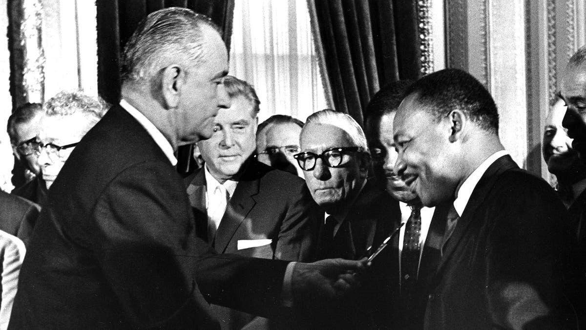 President Lyndon Johnson hands a souvenir pen to the Rev. Dr. Martin Luther King Jr. after signing the Voting Rights Act at the U.S. Capitol in Washington on Aug. 6, 1965.