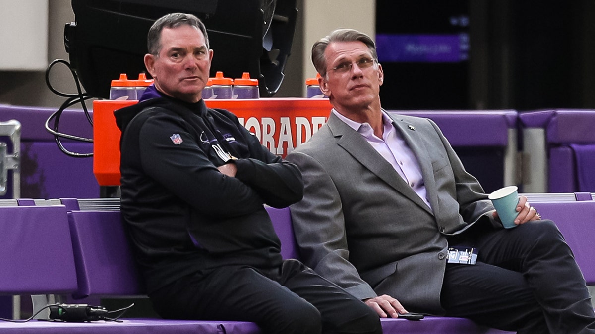 Head coach Mike Zimmer of the Minnesota Vikings, left, and general manager Rick Spielman talk before the start of a preseason game against the Indianapolis Colts at U.S. Bank Stadium on Aug. 21, 2021, in Minneapolis, Minnesota.