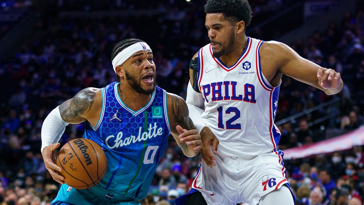 Charlotte Hornets' Miles Bridges, left, drives to the basket against Philadelphia 76ers' Tobias Harris, right, during the first half of an NBA basketball game, Wednesday, Jan. 12, 2022, in Philadelphia.