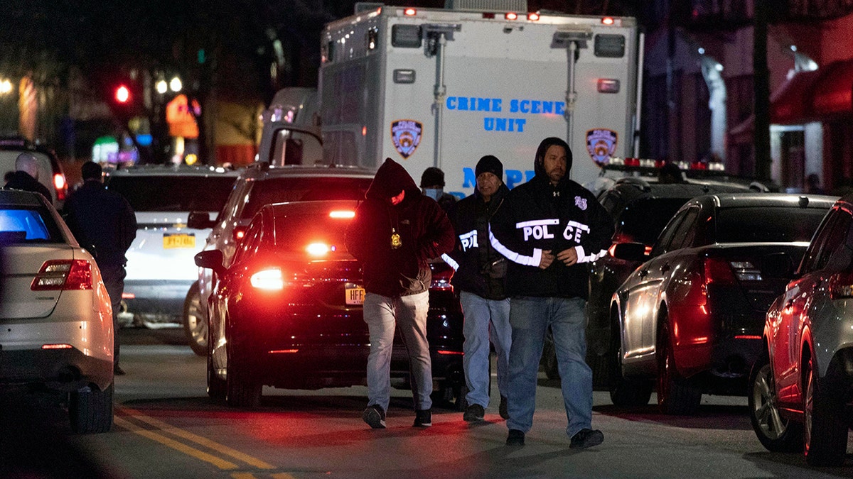 NYPD officers investigate the scene of a shooting in Harlem