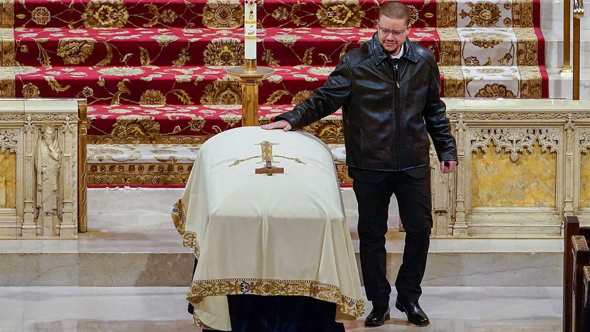 NEW YORK, NY - JANUARY 28: Jeffrey Rivera, the brother of New York City Police Officer Jason Rivera's, touches his casket after eulogizing him during his funeral mass at St. Patricks Cathedral on January 28, 2022 in New York, NY. Rivera and his partner, Officer Wilbert Mora, were fatally wounded when a gunman ambushed them in an apartment as they responded to a family dispute last week.