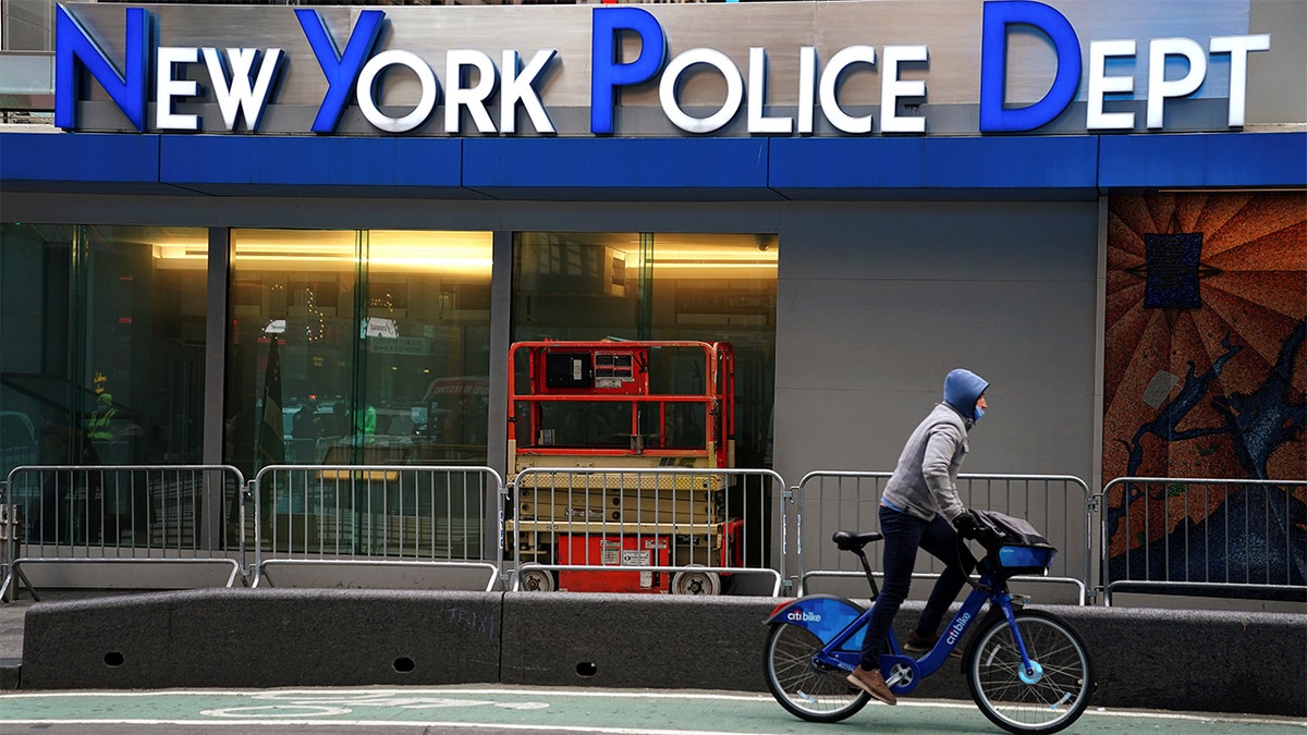 Cyclist riding past NYPD headquarters in New York City
