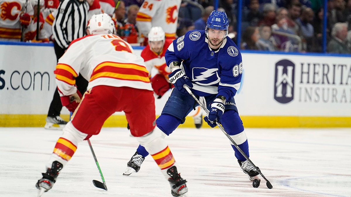 Tampa Bay Lightning right wing Nikita Kucherov (86) moves the puck towards Calgary Flames defenseman Christopher Tanev (8) during the second period of an NHL hockey game Thursday, Jan. 6, 2022, in Tampa, Fla.