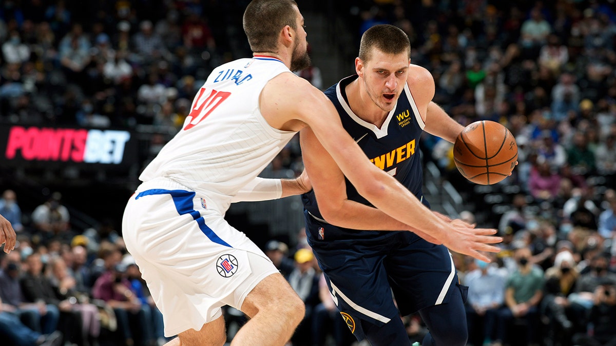 Denver Nuggets center Nikola Jokic, right, drives the lane as Los Angeles Clippers center Ivica Zubac defends in the first half of an NBA basketball game Wednesday, Jan. 19, 2022, in Denver.