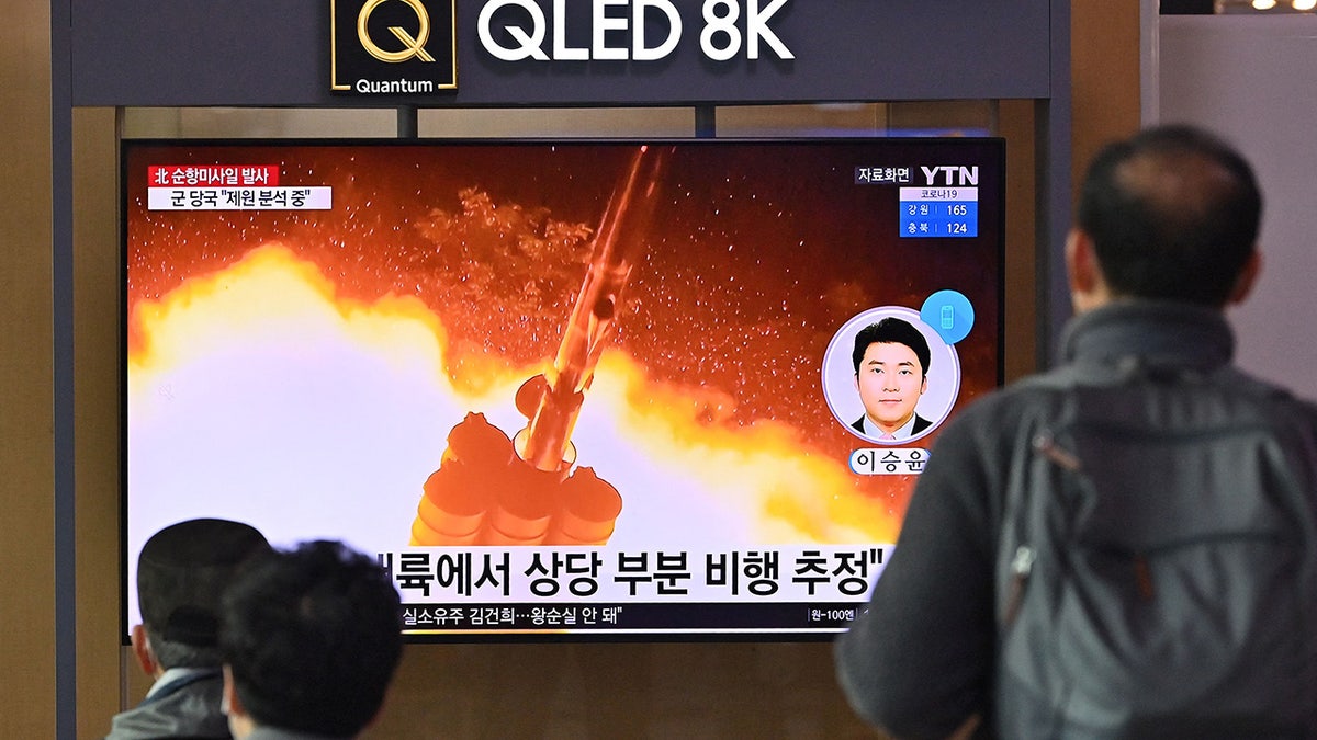 People watch a television screen showing a news broadcast with file footage of a North Korean missile test, at a railway station in Seoul on January 25, 2022, after North Korea fired two suspected cruise missiles according to the South's military. (Photo by JUNG YEON-JE/AFP via Getty Images)